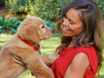 A woman holds a small puppy in her arms