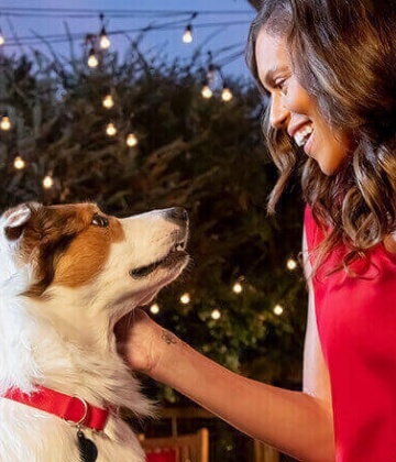 A woman pets her happy dog